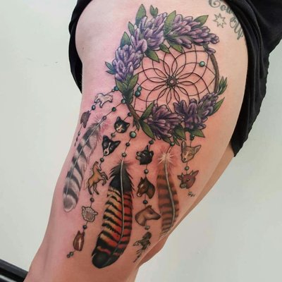 Tatouage plume attrape rêve et fleurs sur le coté de la cuisse